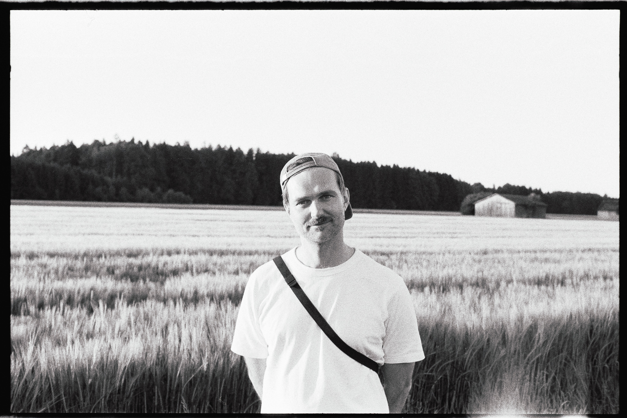 Michael Ciesielski mit Kappe in einem Feld vor einem Waldrand.